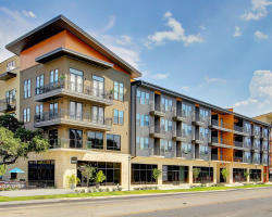 Modern multi-story apartment building with balconies on a sunny day.